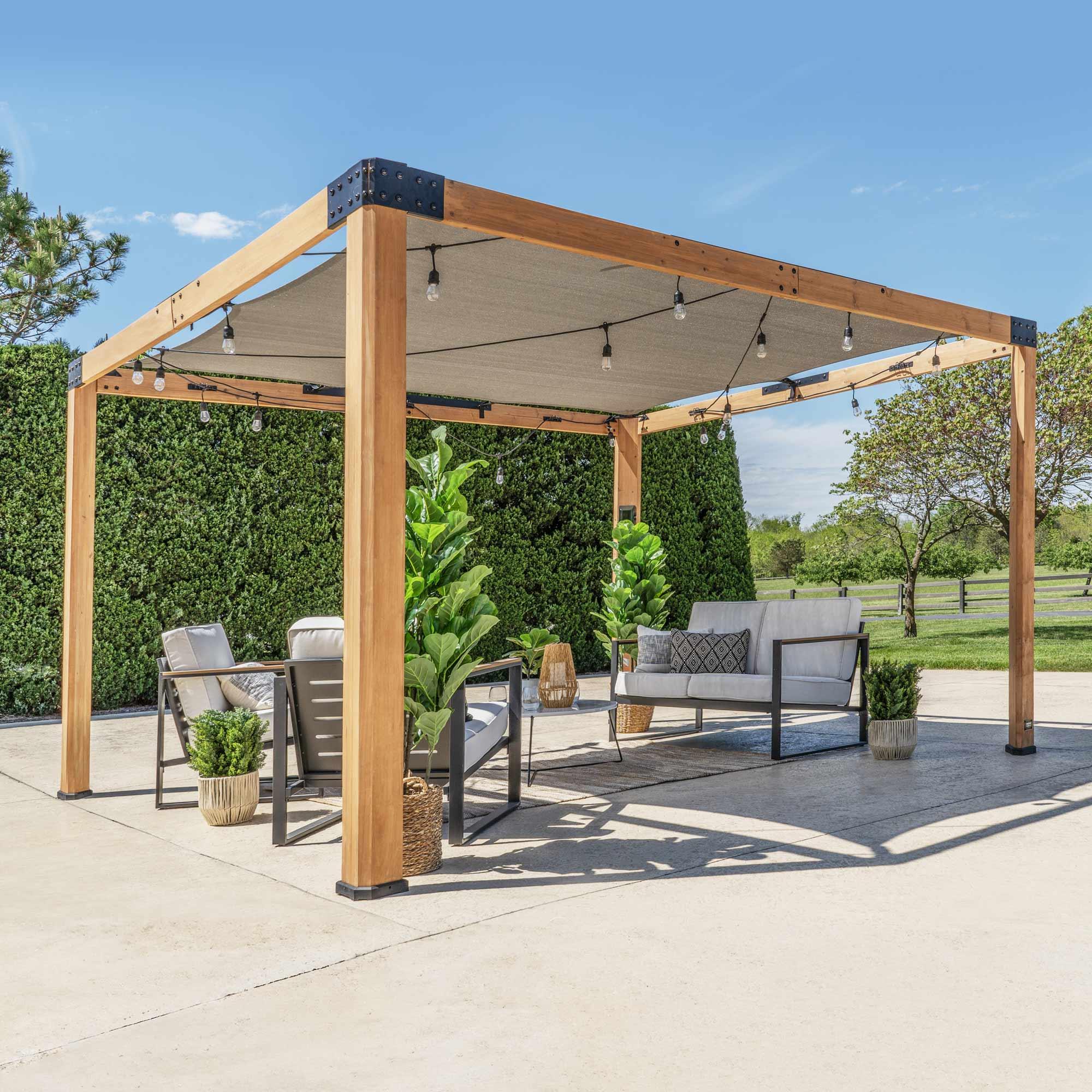 Backyard Discovery Brendan sail shade pergola in light brown cedar with a grey fabric canopy over a patio seating set
