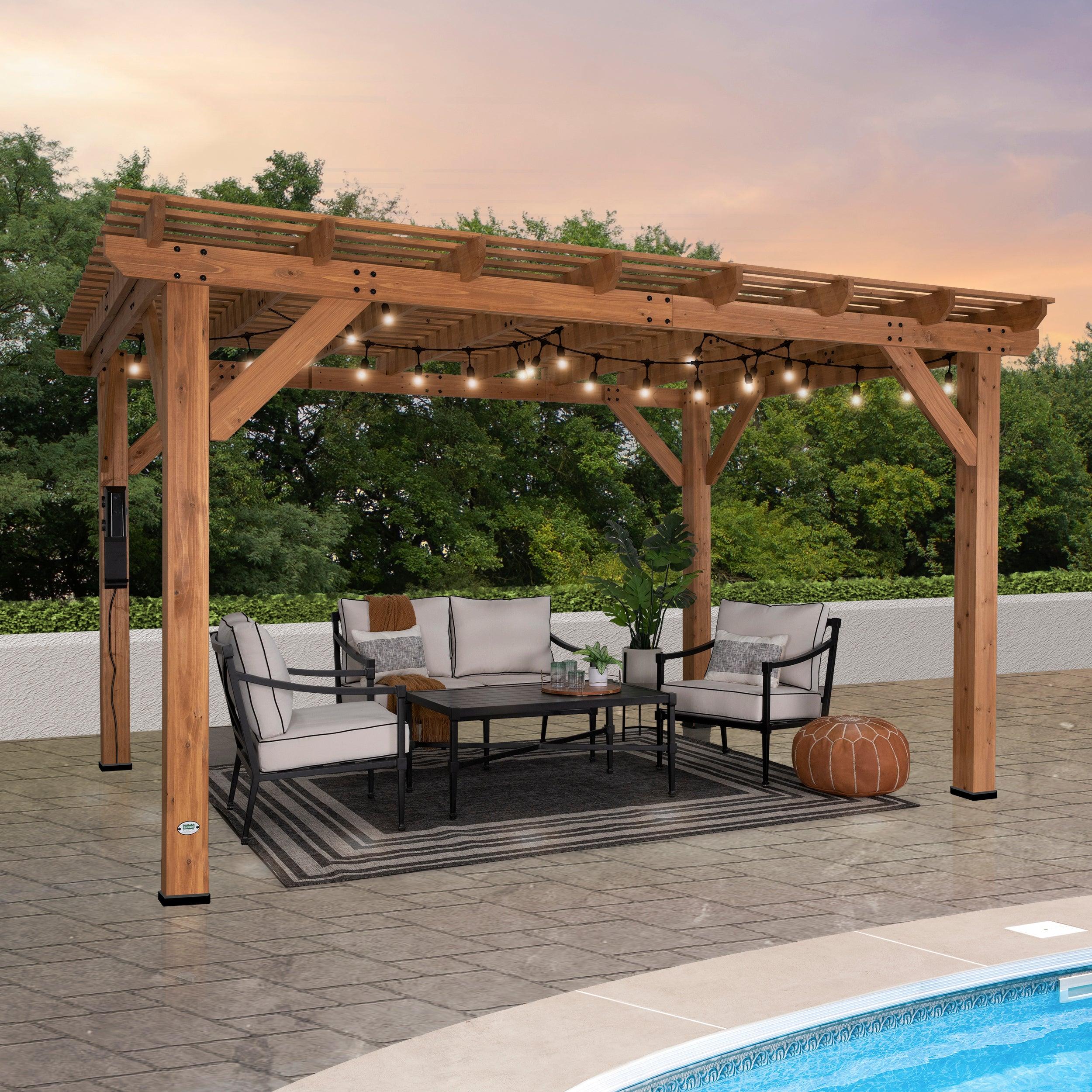 Backyard Discovery Delray cedar pergola in light brown stain over a poolside sofa set at dusk