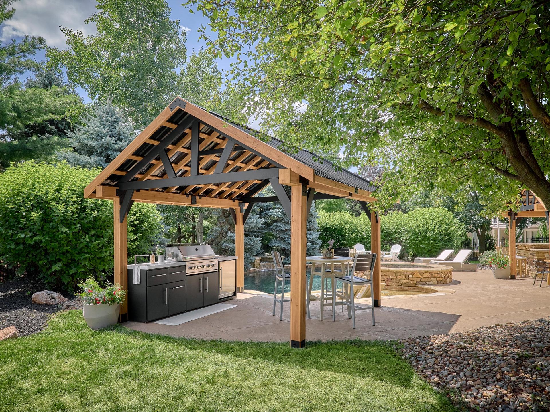 Backyard Discovery Lodge cedar and steel gazebo with a gabled steel roof over an outdoor kitchen and dining table