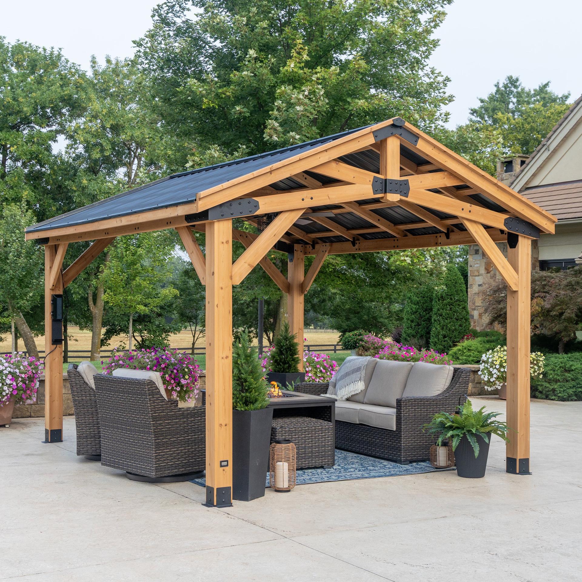 Backyard Discovery 14x12 peak roof cedar gazebo with a dark steel roof over wicker lounge seating