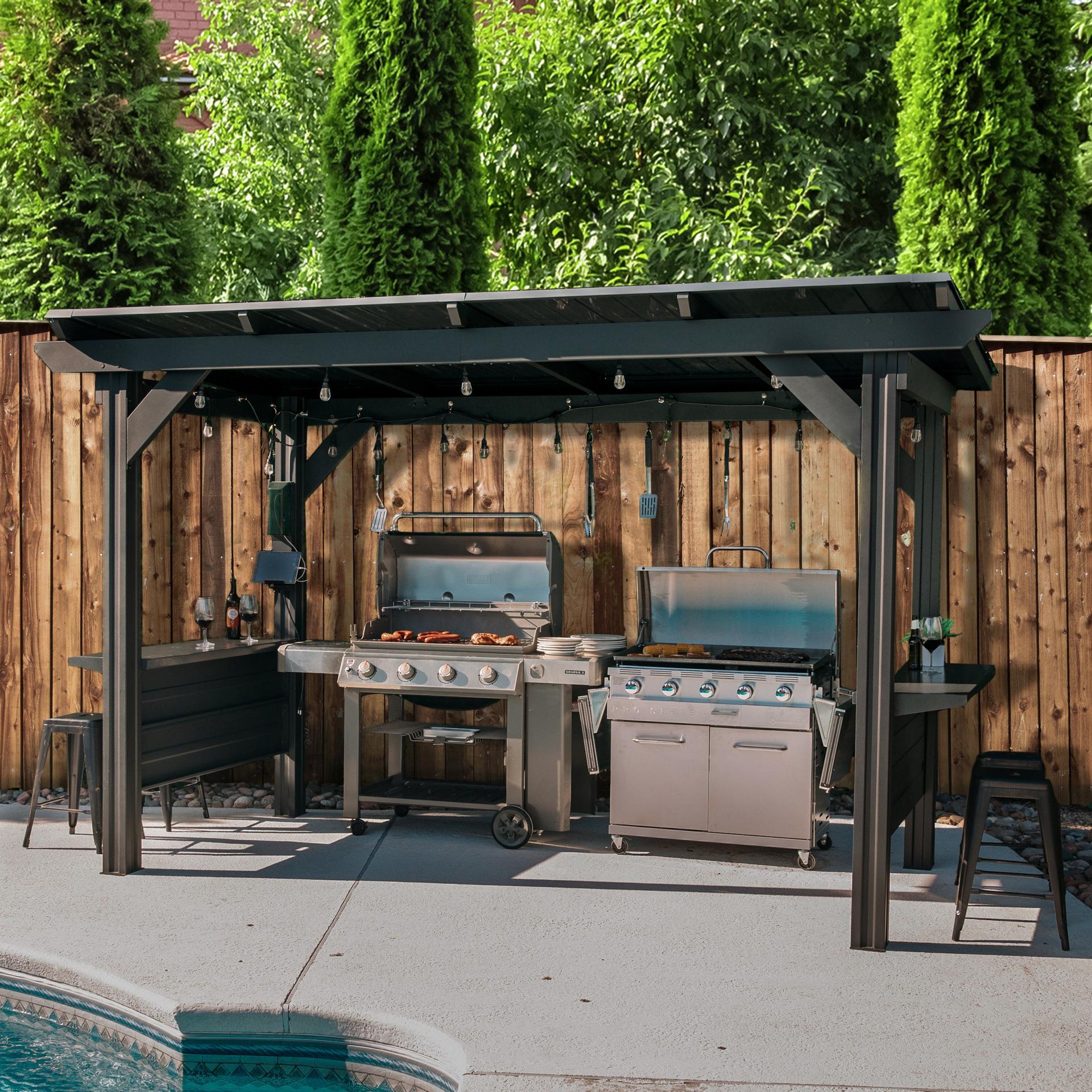 Backyard Discovery Rockport XL black steel grill gazebo covering two grills in a fenced backyard