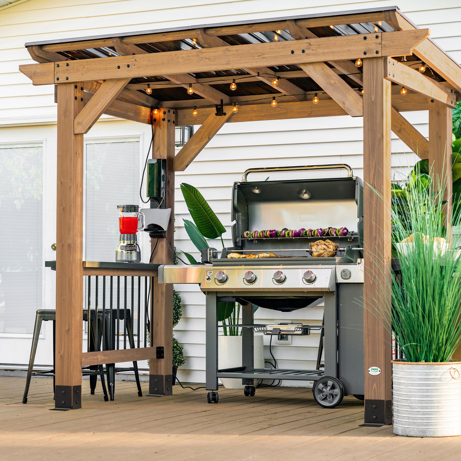 Backyard Discovery Saxony cedar grill gazebo with a steel roof over a gas grill and bar counters
