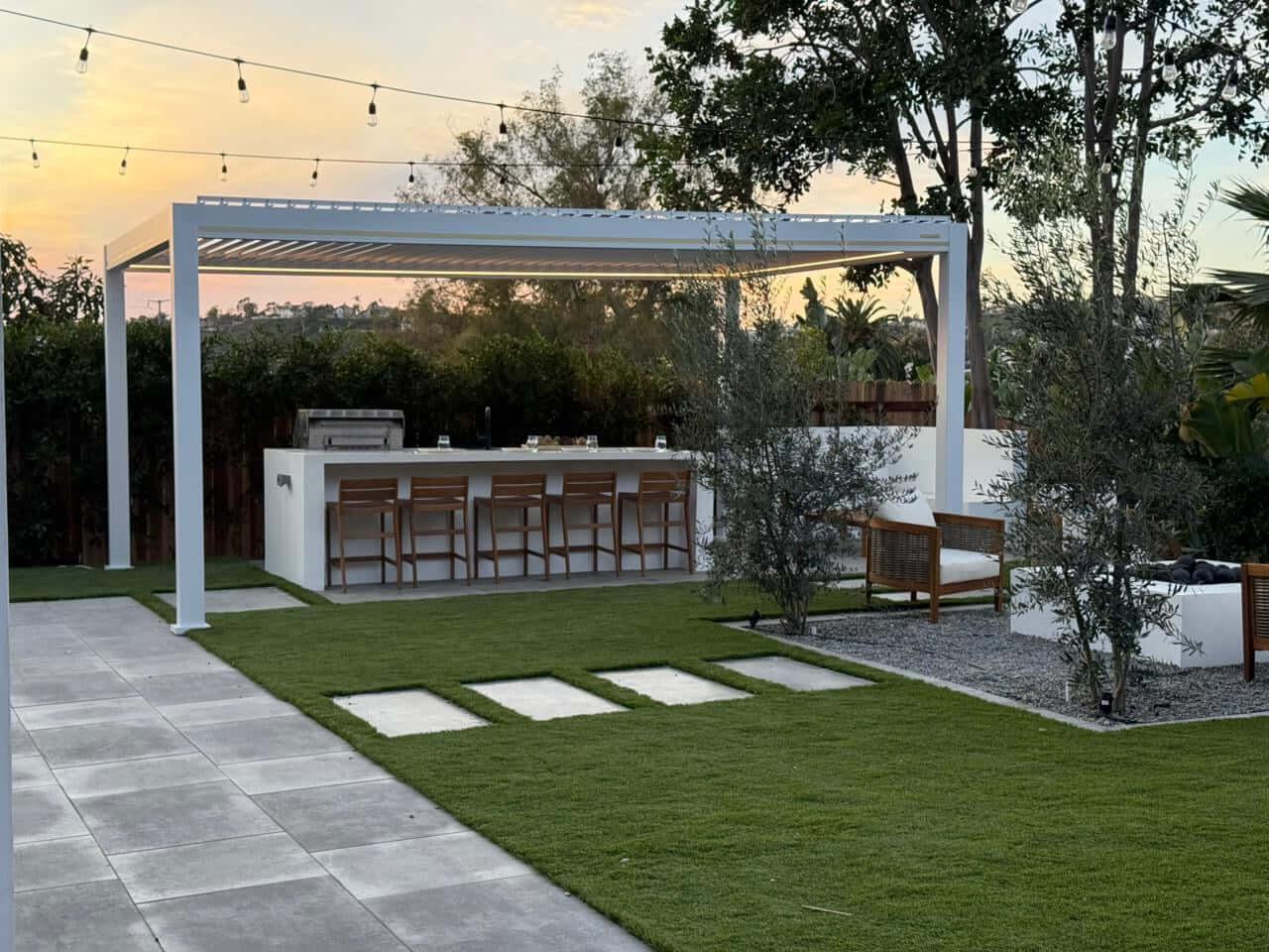 White Villa Pergola 2.0 over an outdoor kitchen bar at sunset with the edge lighting on