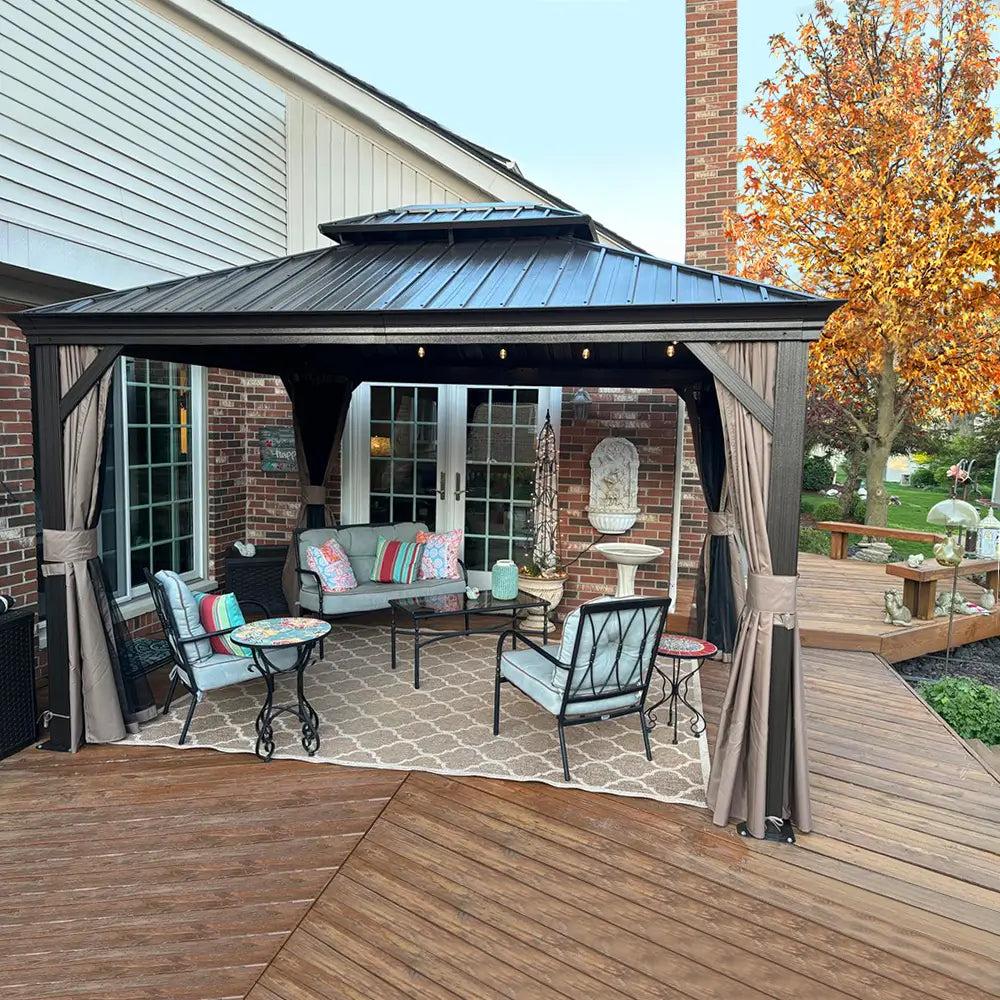 Domi Outdoor Living aluminum hardtop gazebo with a gray double roof and brown curtains over a patio set on a wood deck