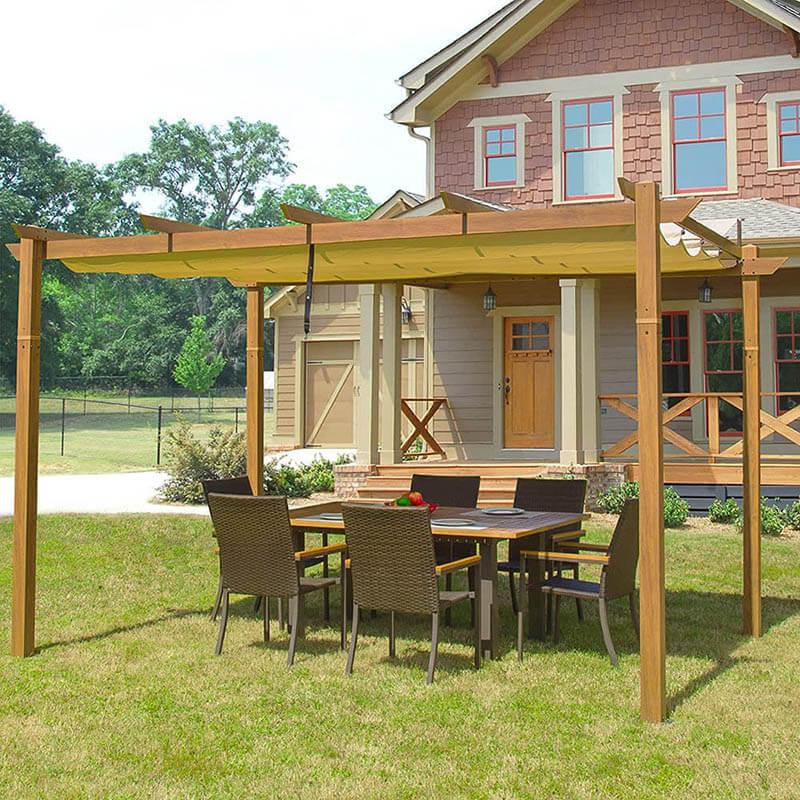 Domi Outdoor Living wood-look fabric-top pergola with a tan canopy over a wicker dining set beside a house