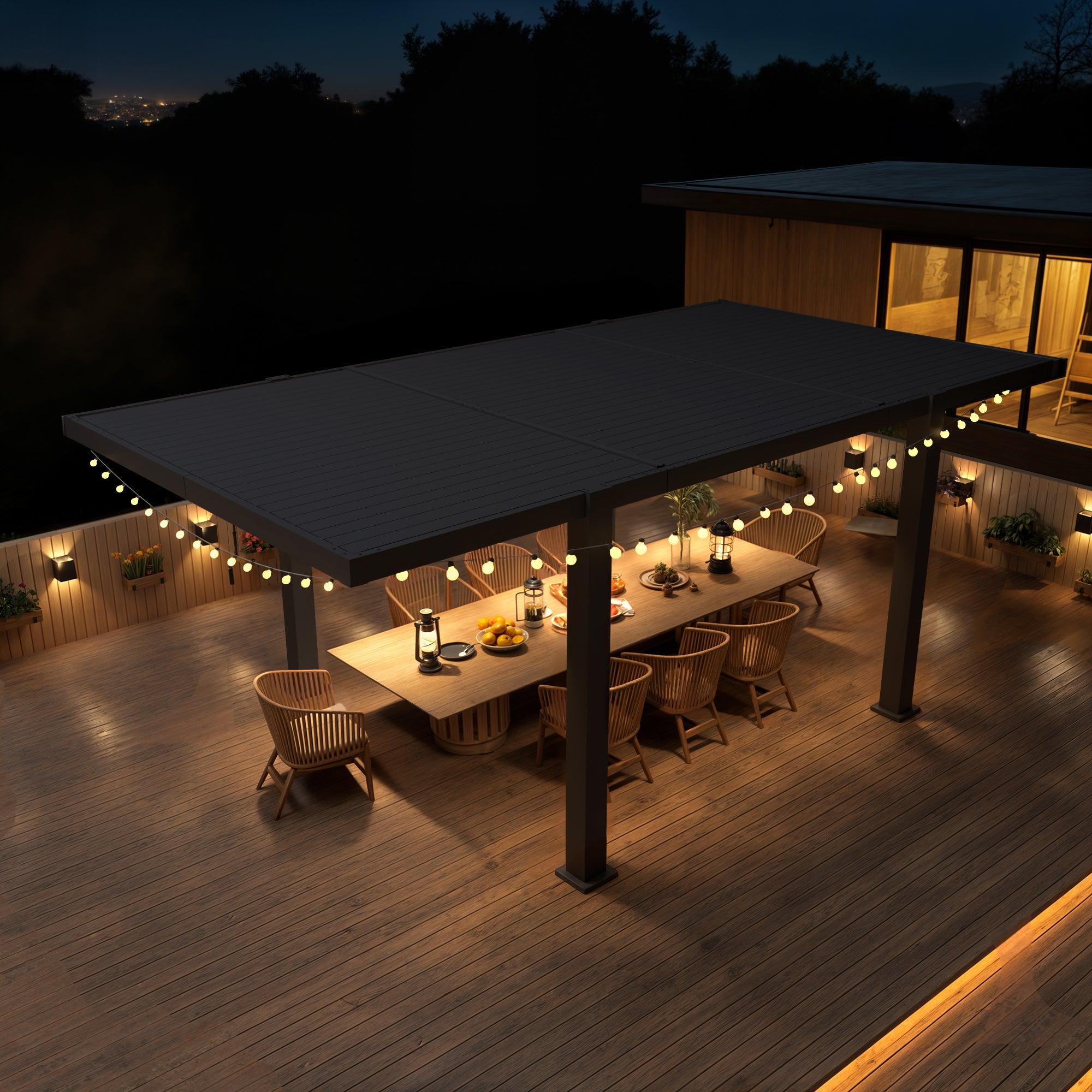 EROMMY T-shaped louvered pergola in black over a decked dining table, lit at night