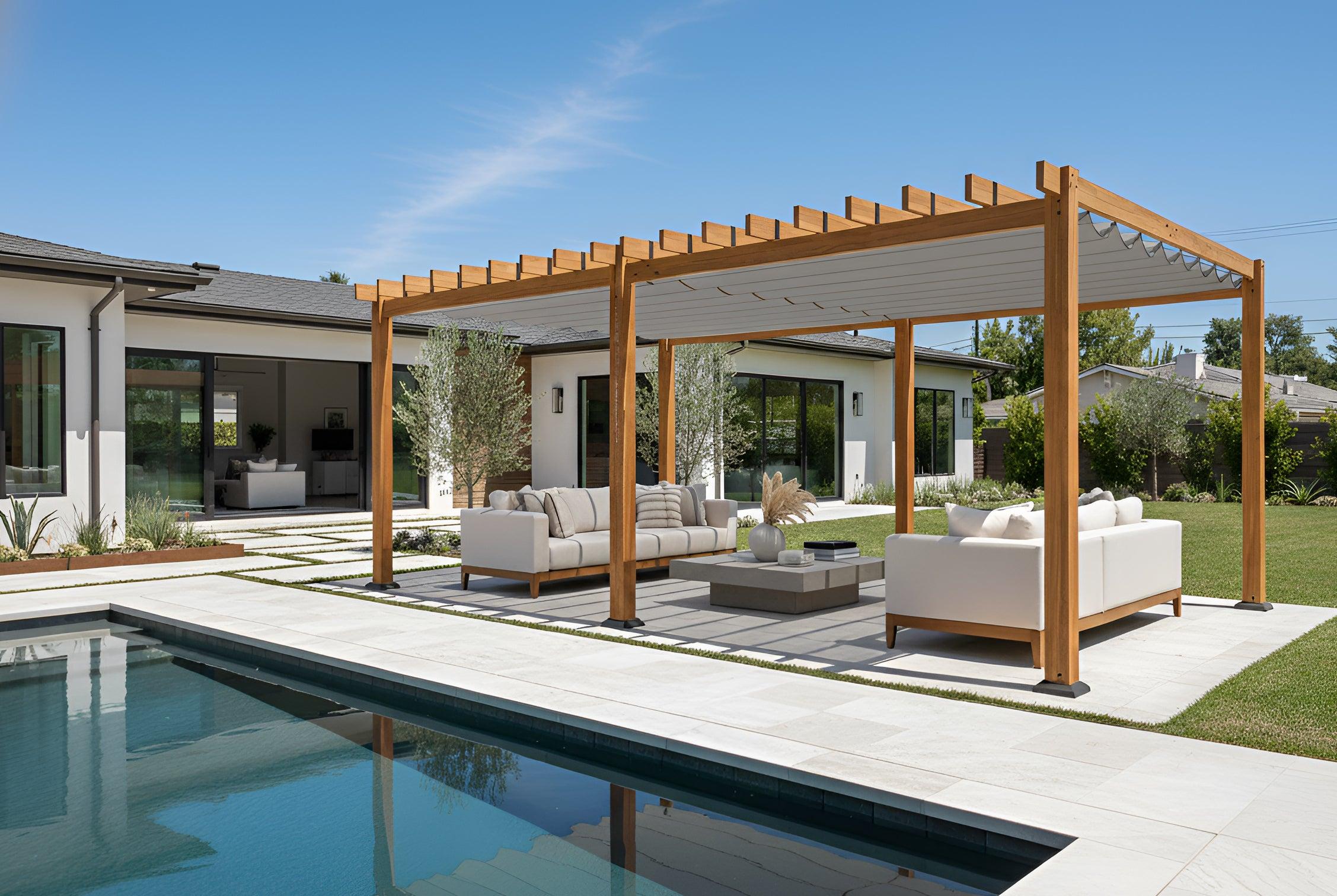 16' x 24' California pergola in Tuscan Cedar with the Sterling Silver canopy drawn, shading poolside sofas beside a white house