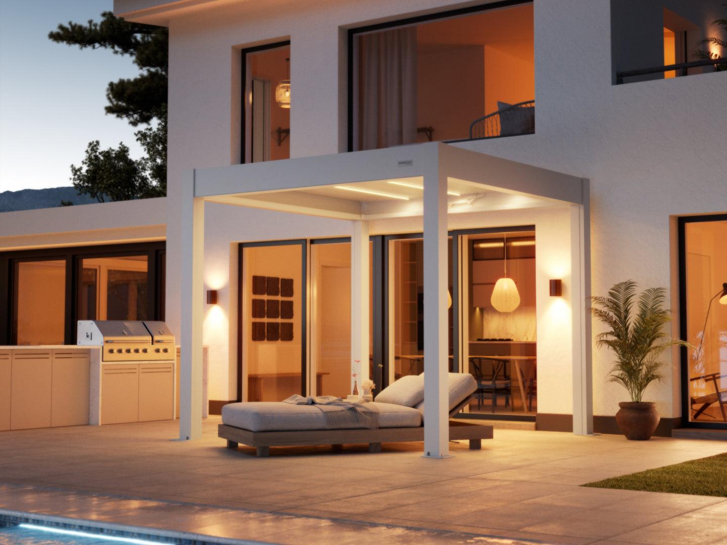 PERGOLUX Skydance S3 motorized louvered pergola in white beside a modern house at dusk