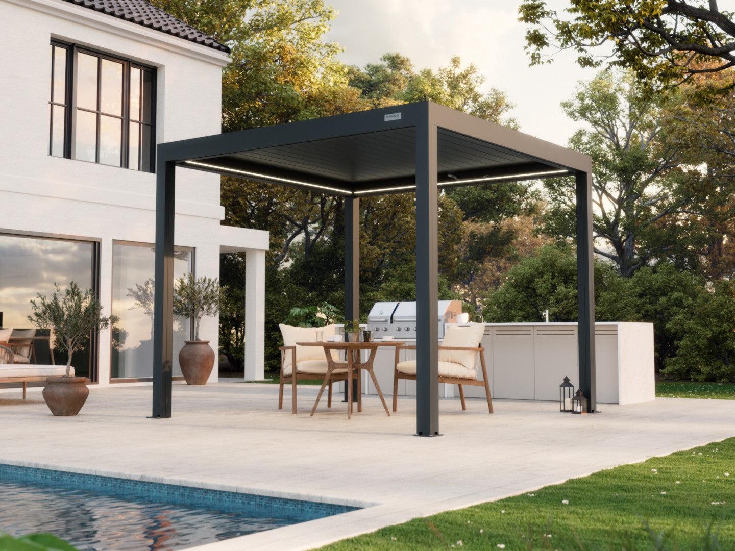 PERGOLUX Sundream S3 louvered pergola in anthracite beside a white house with a patio dining set