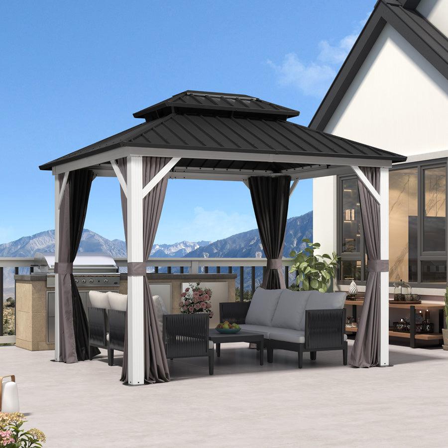 Modern white-pole gazebo beside a house with a sofa set under the grey roof