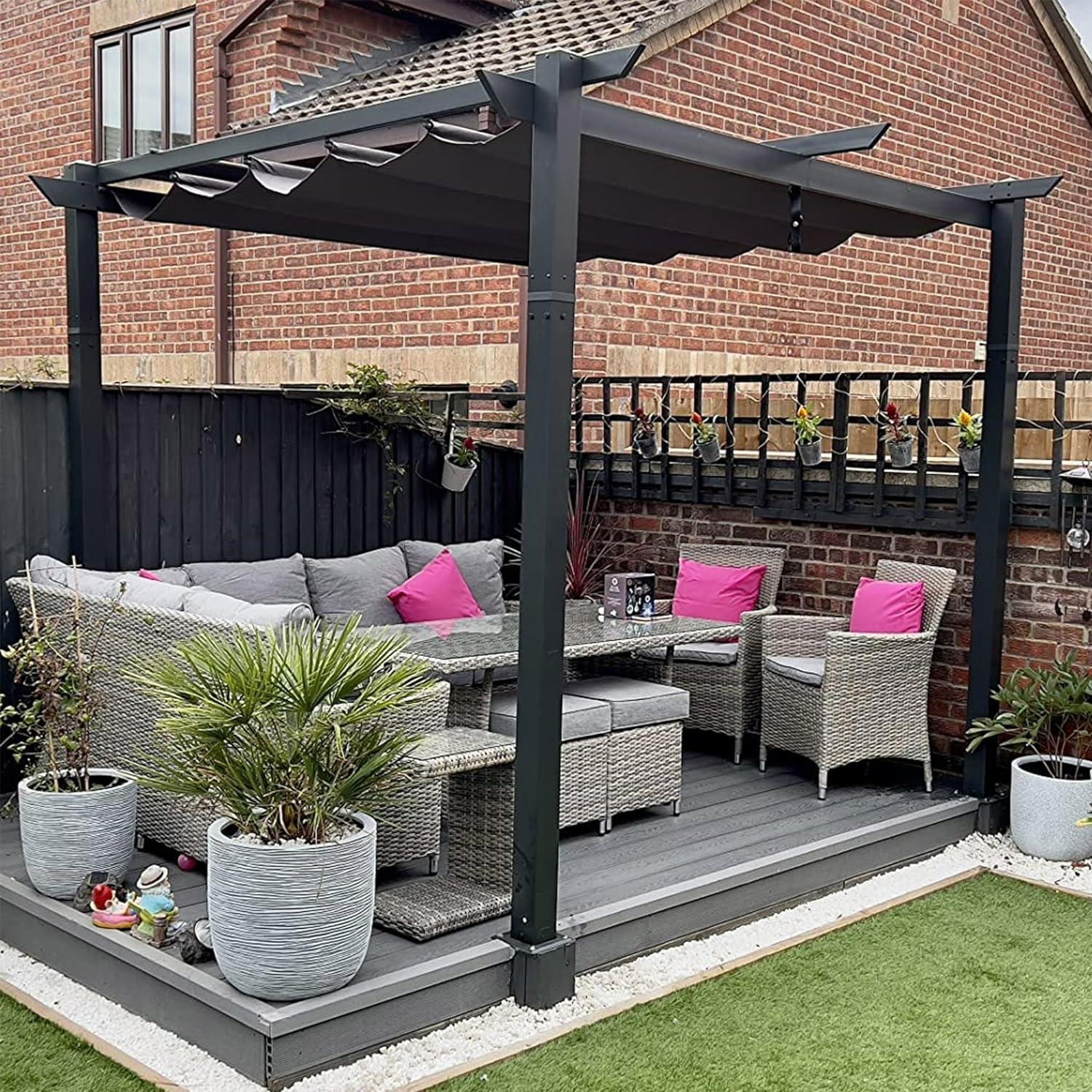 Grey PURPLE LEAF retractable canopy pergola on a garden deck with rattan seating against a brick house