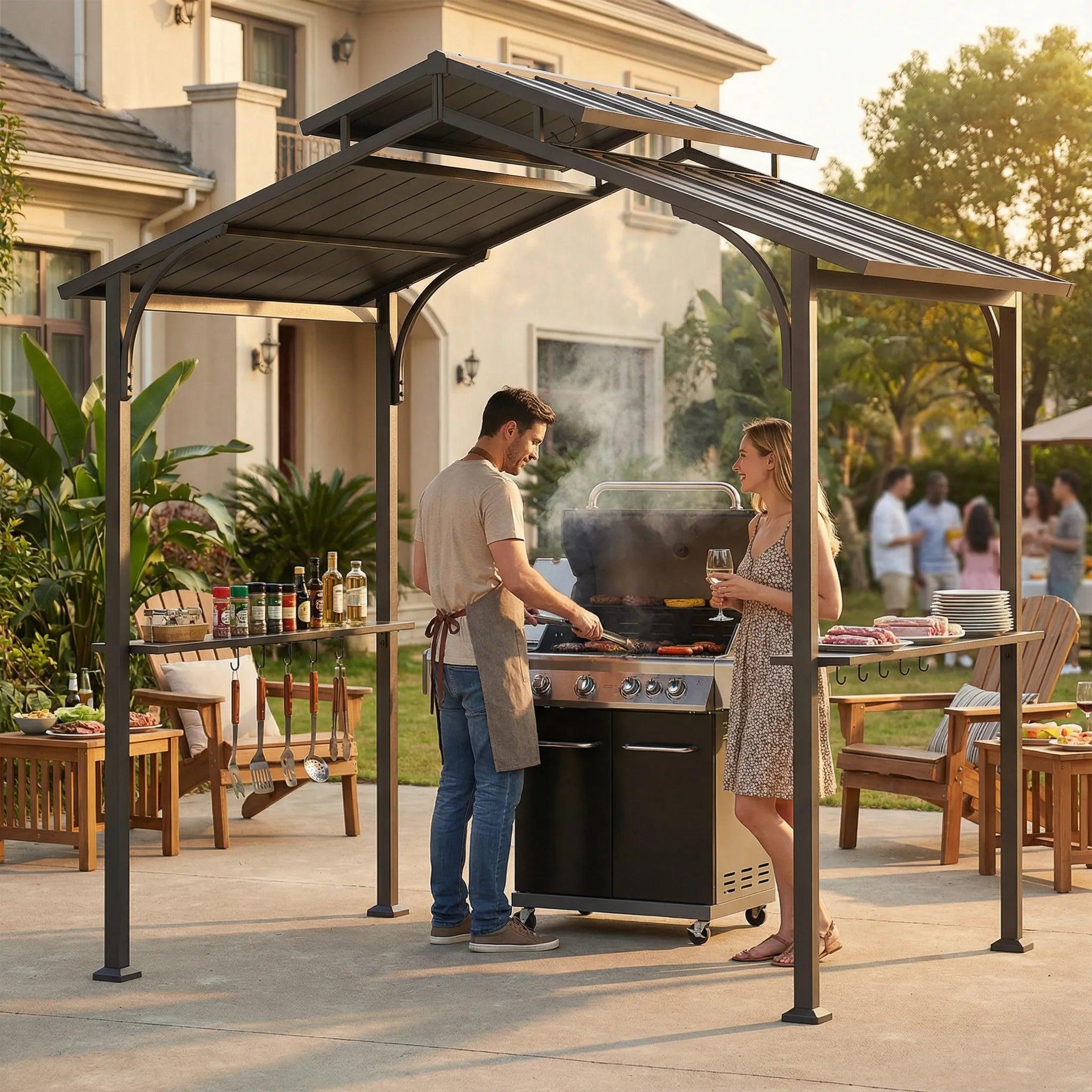 Sunjoy Classic Urban 5x8 grill station on a patio with two people cooking at a gas grill and a garden party behind
