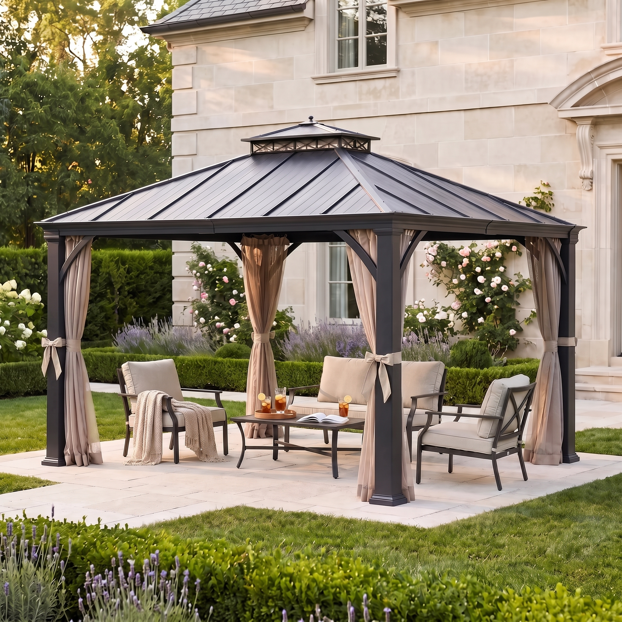 Sunjoy Crown Lattice hardtop gazebo on a terrace beside a stone house, curtains tied back over a laid dining table