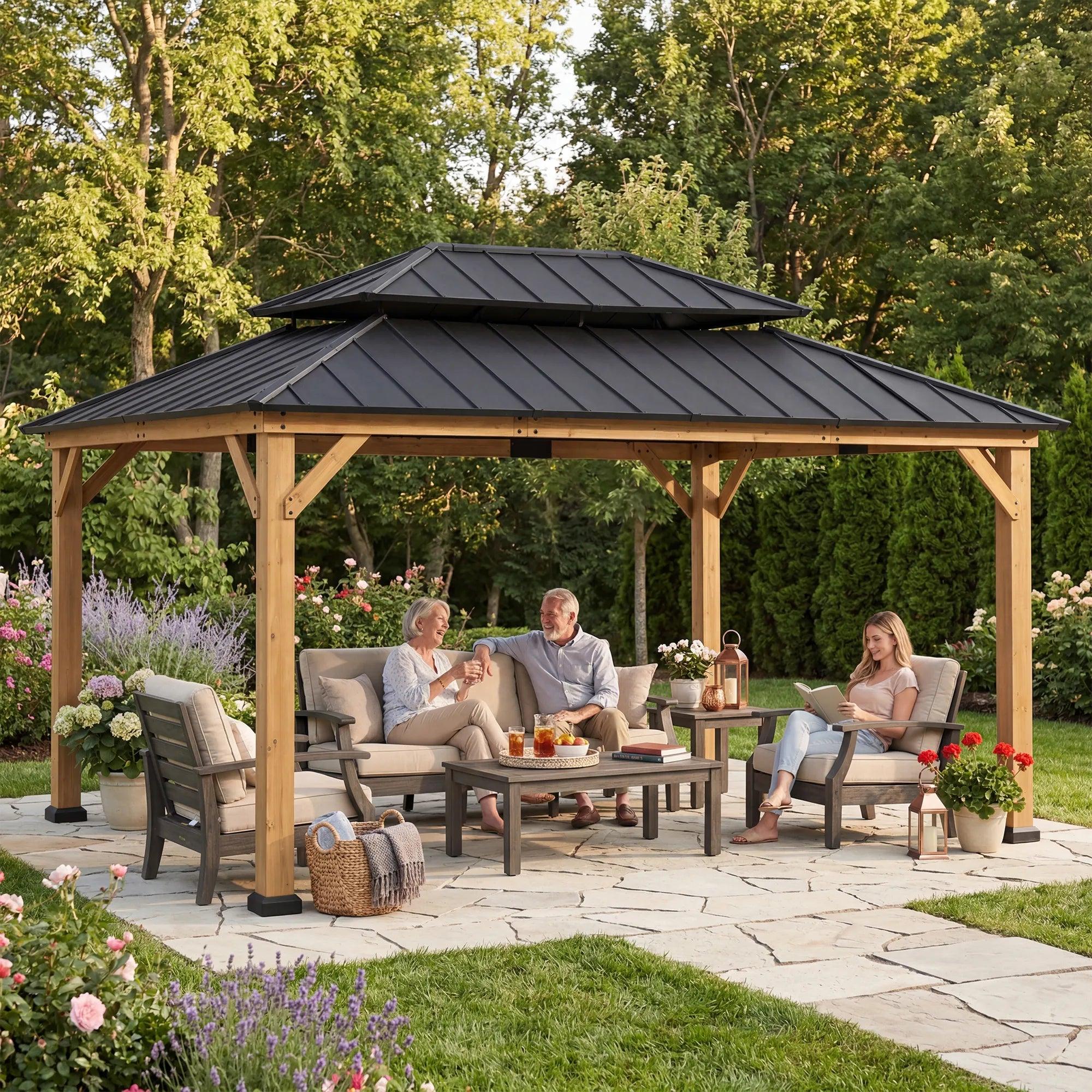 Sunjoy Double-Tier Cedar 12x16 gazebo on a flagstone patio with four people seated on sofas around a low table beneath it