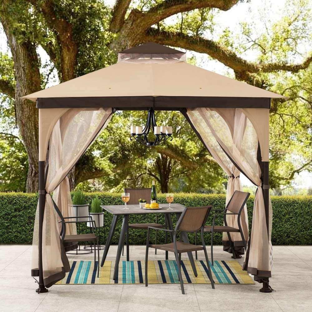 Sunjoy 9x9 garden soft top gazebo under a large tree, sheltering a patio dining set on a striped rug
