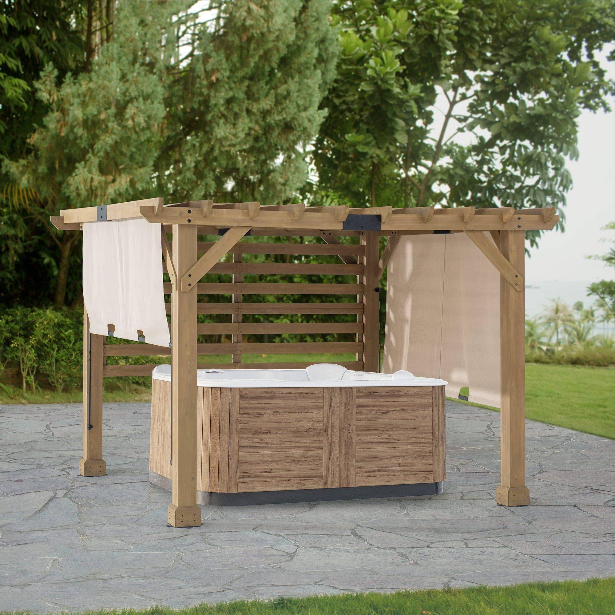 Sunjoy 10x11 cedar privacy pergola over a hot tub on a flagstone patio, canopy panels lowered on both sides