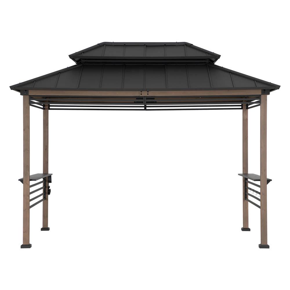 Sunjoy Pro-Grill Fenced Station 8x12 in brown, studio view of the wooden frame under a two-tier steel hardtop with side shelves and a slatted fence panel along one side
