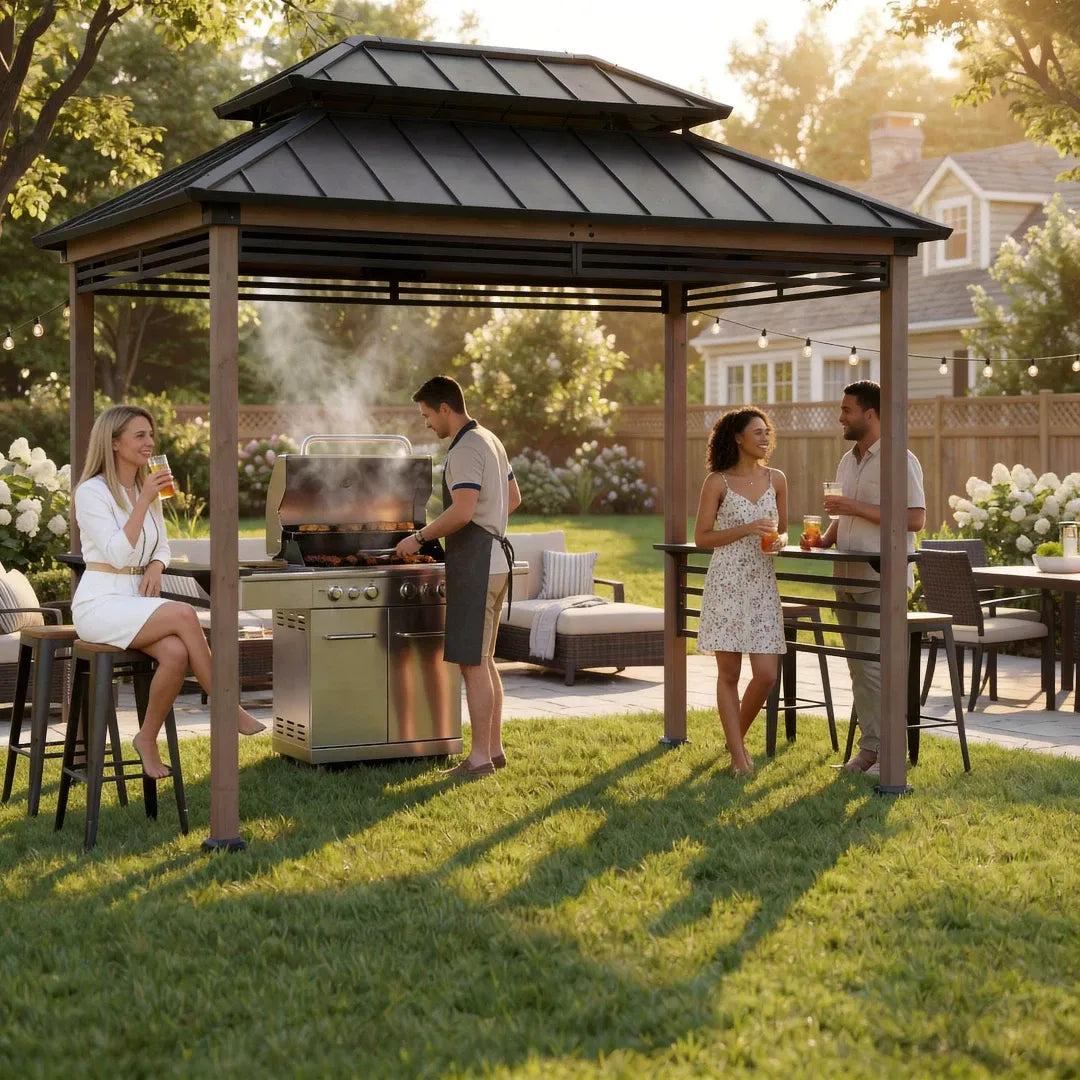 Sunjoy Pro-Grill Fenced Station 8x12 on a lawn with four people around a gas grill beneath the roof and drinks on the side shelf