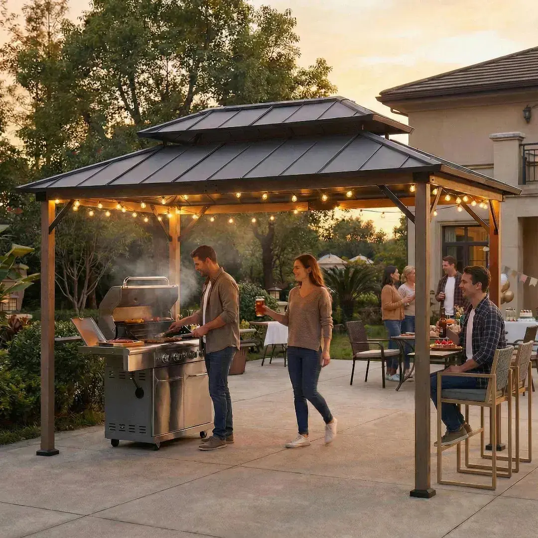 Sunjoy Pro-Grill Performance Station 8x12 on a patio at dusk, string lights lit under the roof and a gas grill in use beneath it
