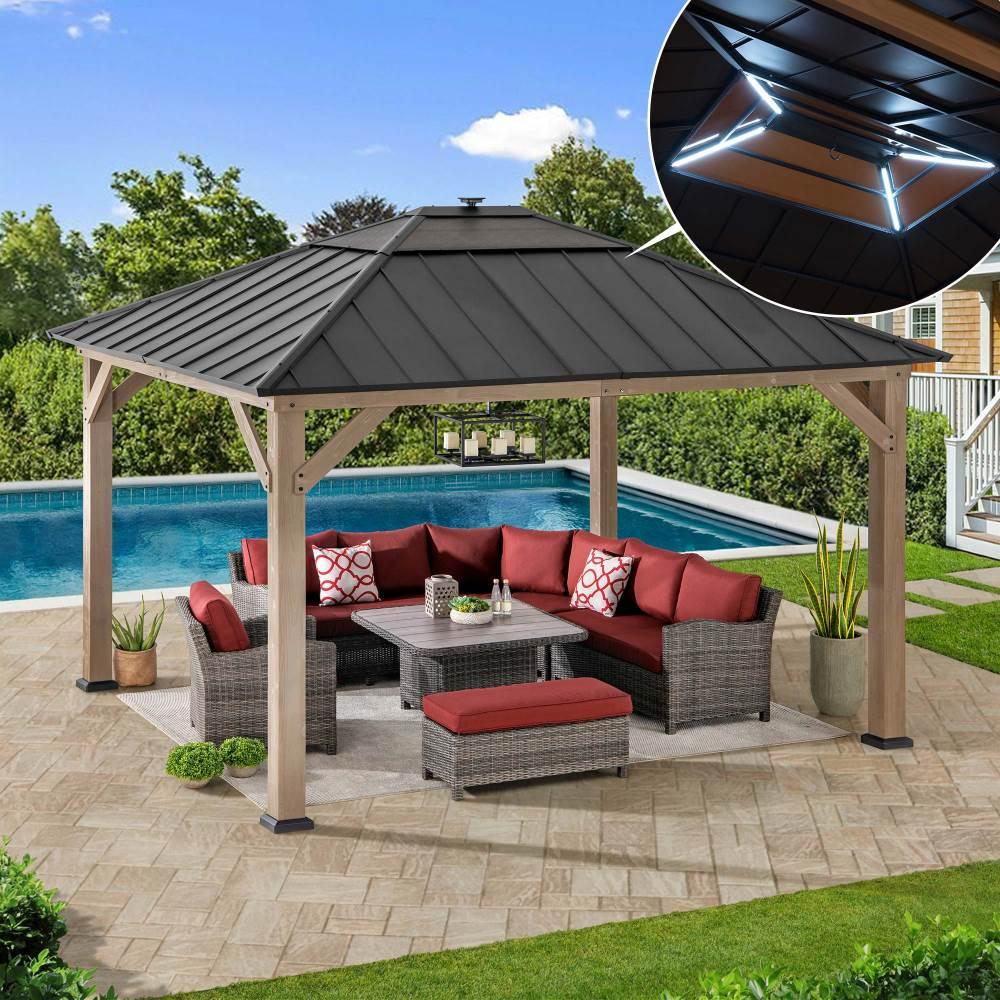 Sunjoy Smart Solar 11x13 wooden gazebo beside a swimming pool, sheltering a rattan corner sofa with red cushions