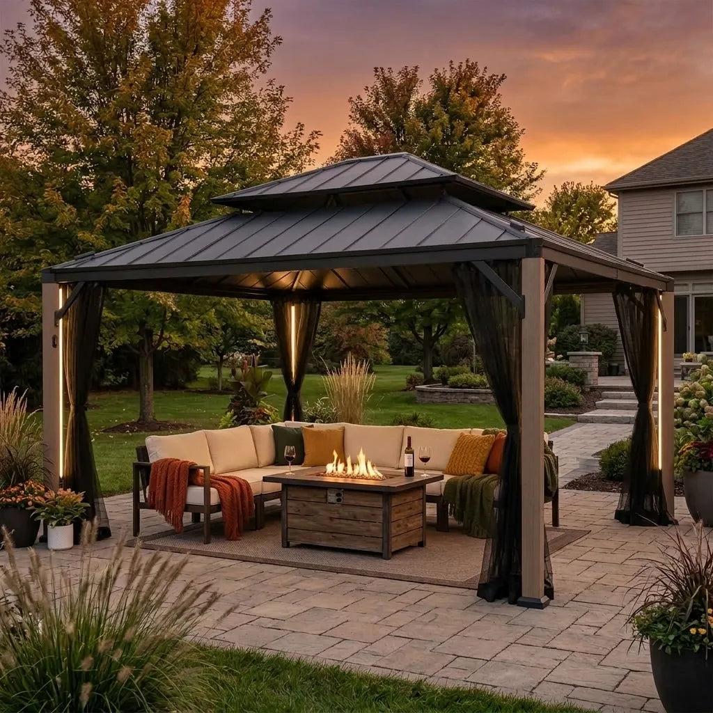 Sunjoy Stanwood 13x15 gazebo on a paved patio at dusk, the column lights on above a sofa and gas fire table