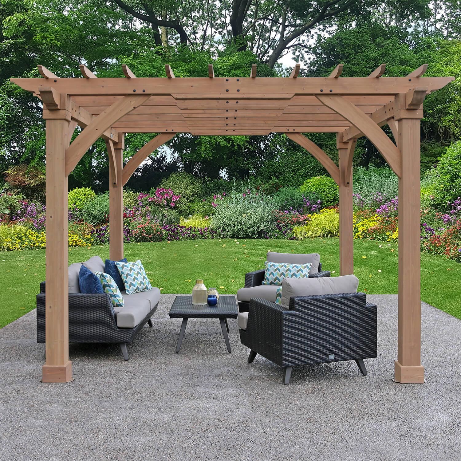 Yardistry 12 x 12 Pergola seen end-on over a garden seating area, with flower borders and lawn behind