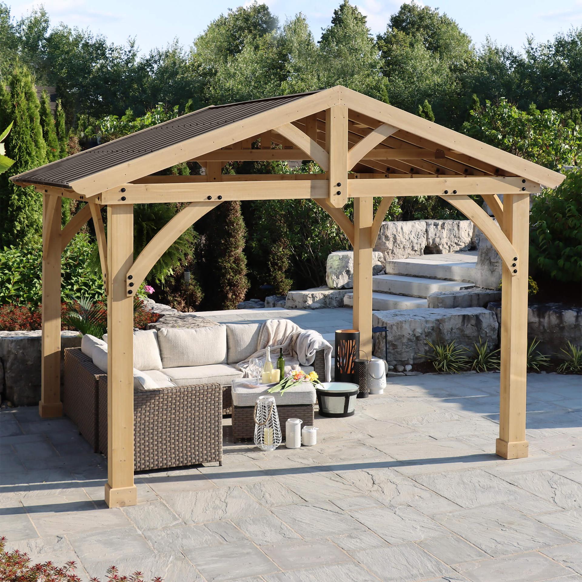 Yardistry 11x13 Carolina pavilion with a cedar gable frame, curved gussets and aluminum roof over a stone patio sofa set