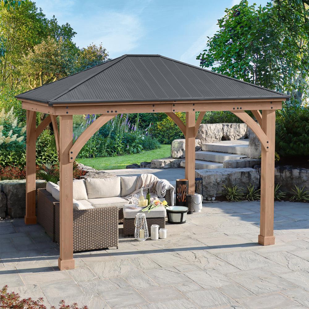 Yardistry 12x14 Everyday Gazebo with a graphite gray aluminum hip roof over a wicker seating group on a stone patio
