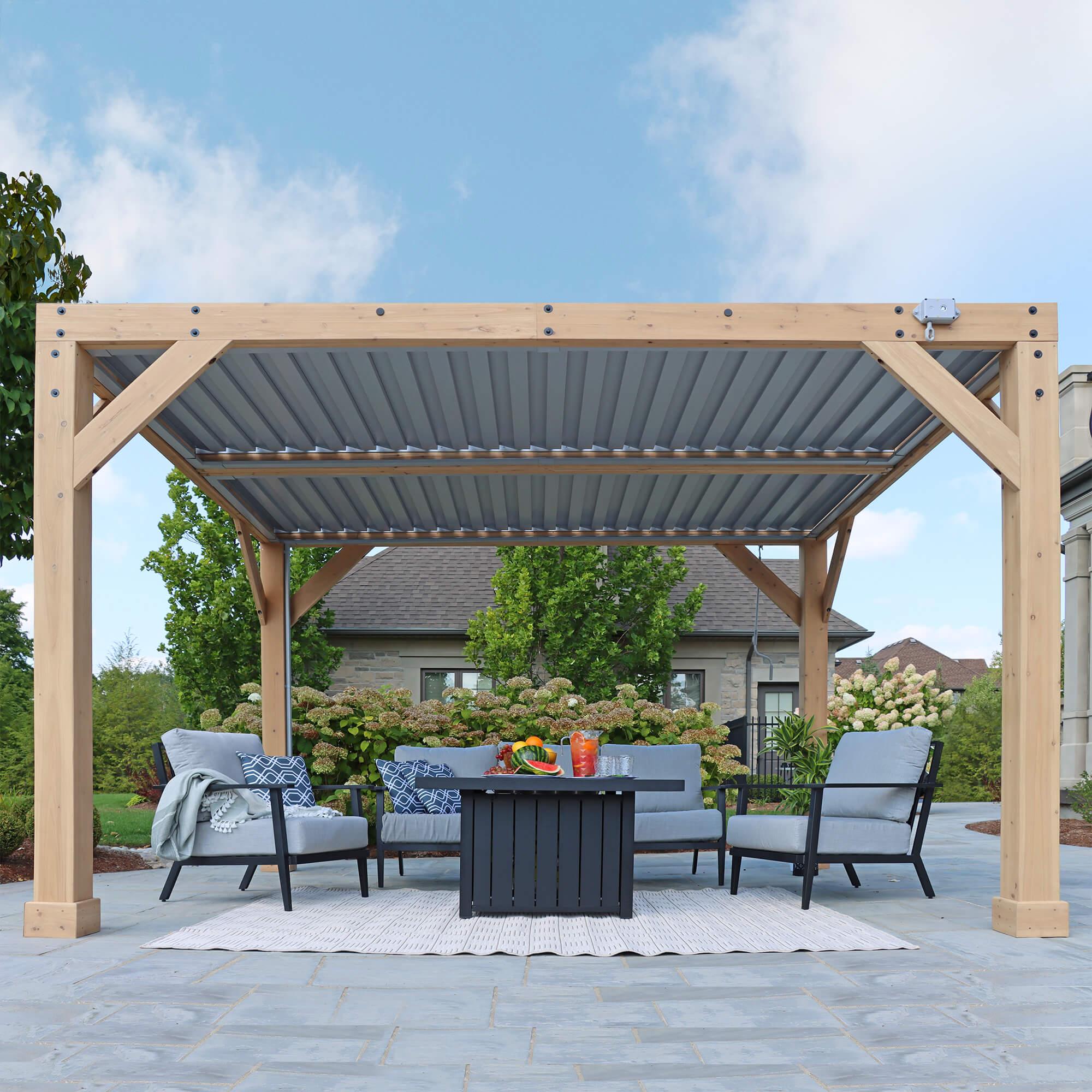Yardistry Meridian Wooden Louvered Pergola in natural cedar with its grey aluminium louvers closed for full shade over a patio lounge set