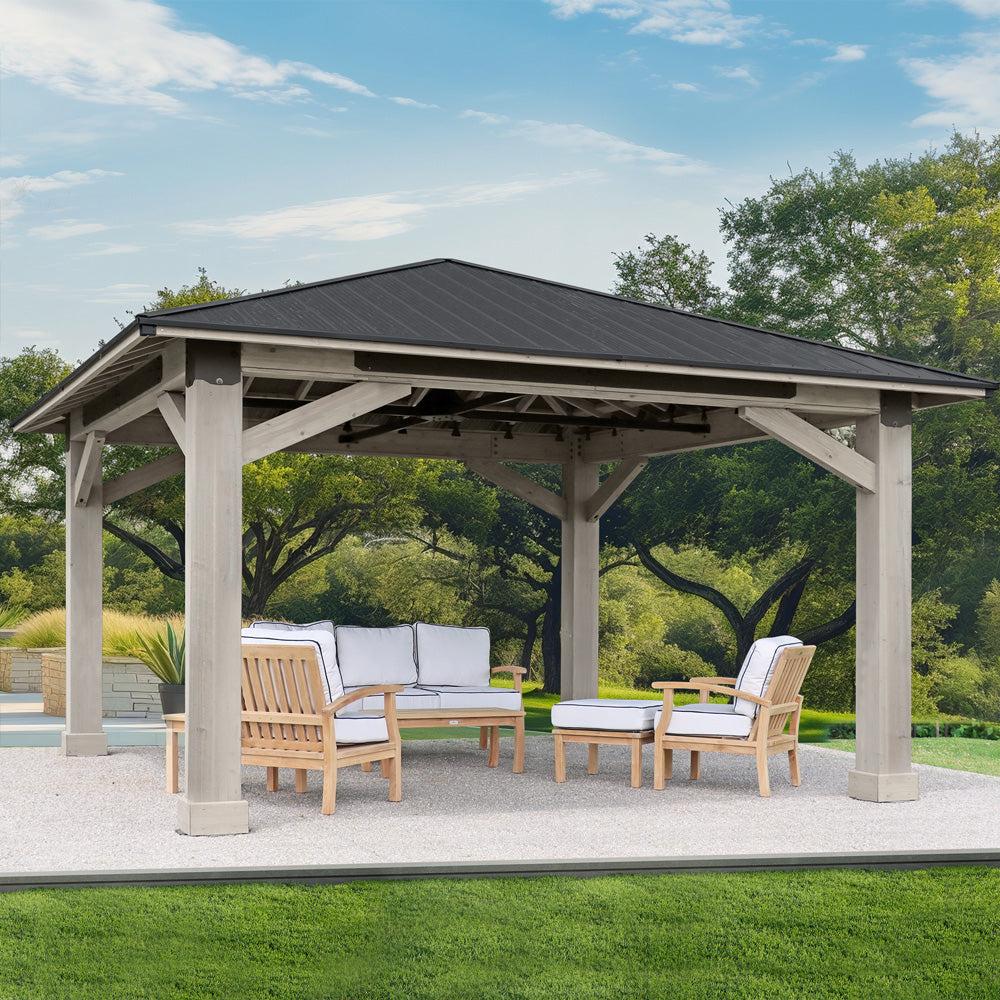 Yardistry 16x16 Timber Frame Gazebo with grey-stained posts and a dark hip roof over outdoor sofa seating
