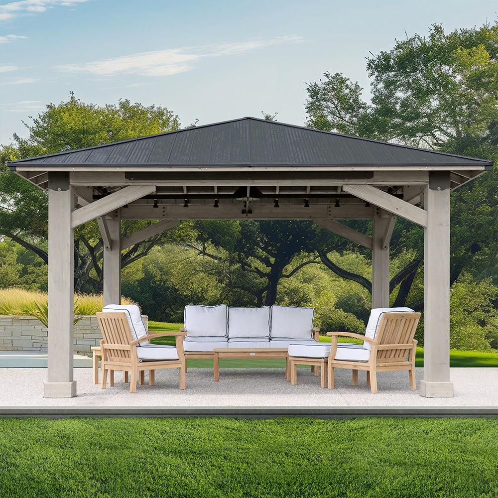 Timber Frame Gazebo on a concrete patio facing the front with a sofa and two armchairs underneath